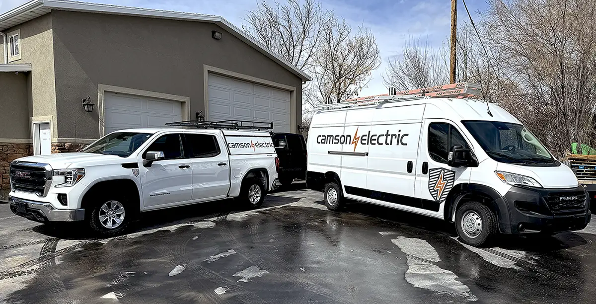 Camson Electric service vehicles parked at a residential job site in Utah
