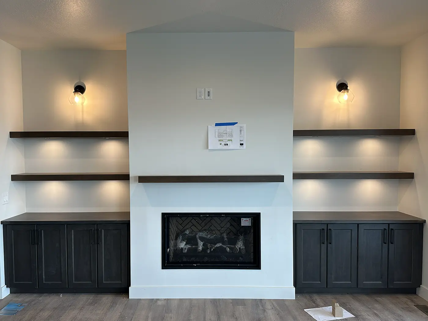 Custom lighting installed on built-in shelving and fireplace features by Camson Electric in a Utah home