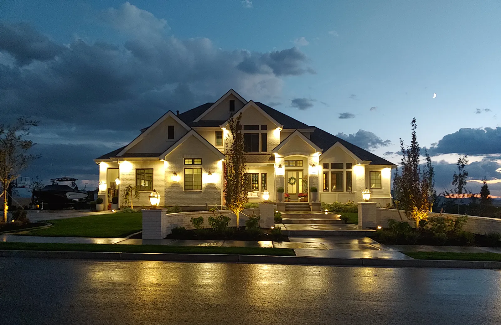 Interior and exterior lighting installation for a custom Utah home featuring landscape lighting, illuminated windows, and architectural lighting by Camson Electric