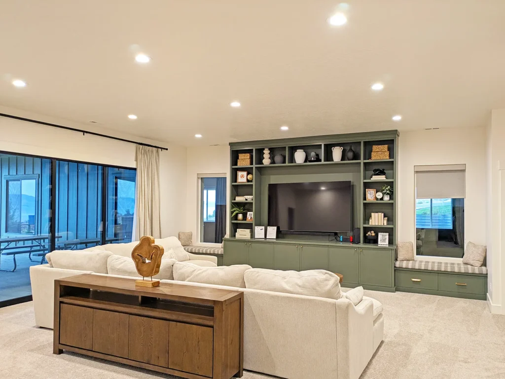 Open living room with recessed ceiling lights and illuminated built-ins around the fireplace